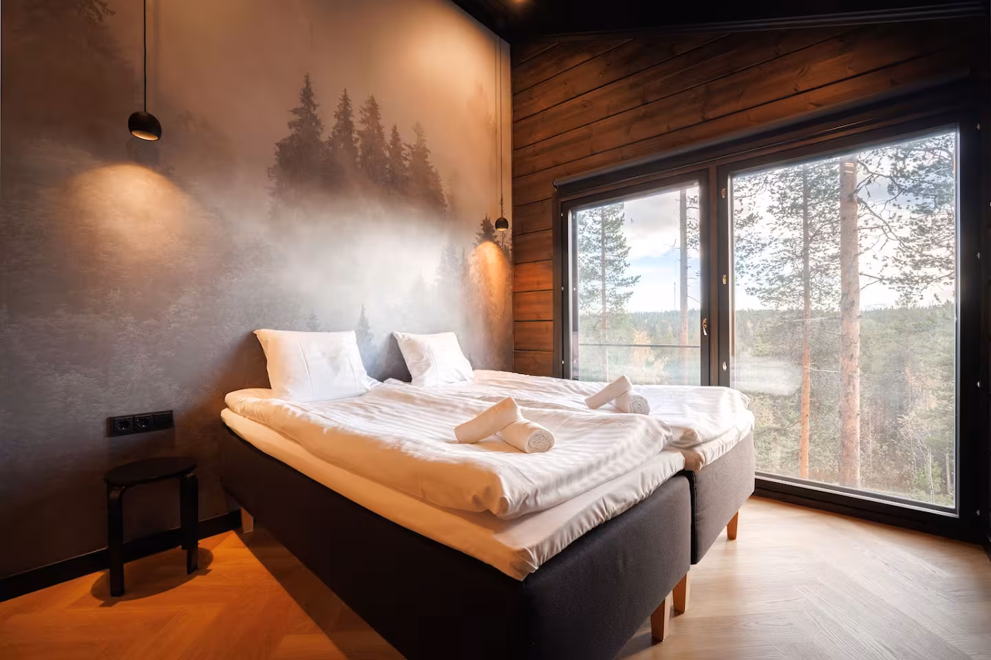 Quiet bedroom in pale wood with linen bedding and a window facing the fells