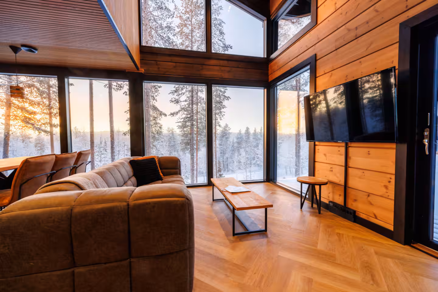 Lounge with deep sofas beneath a high timber ceiling and full-height windows